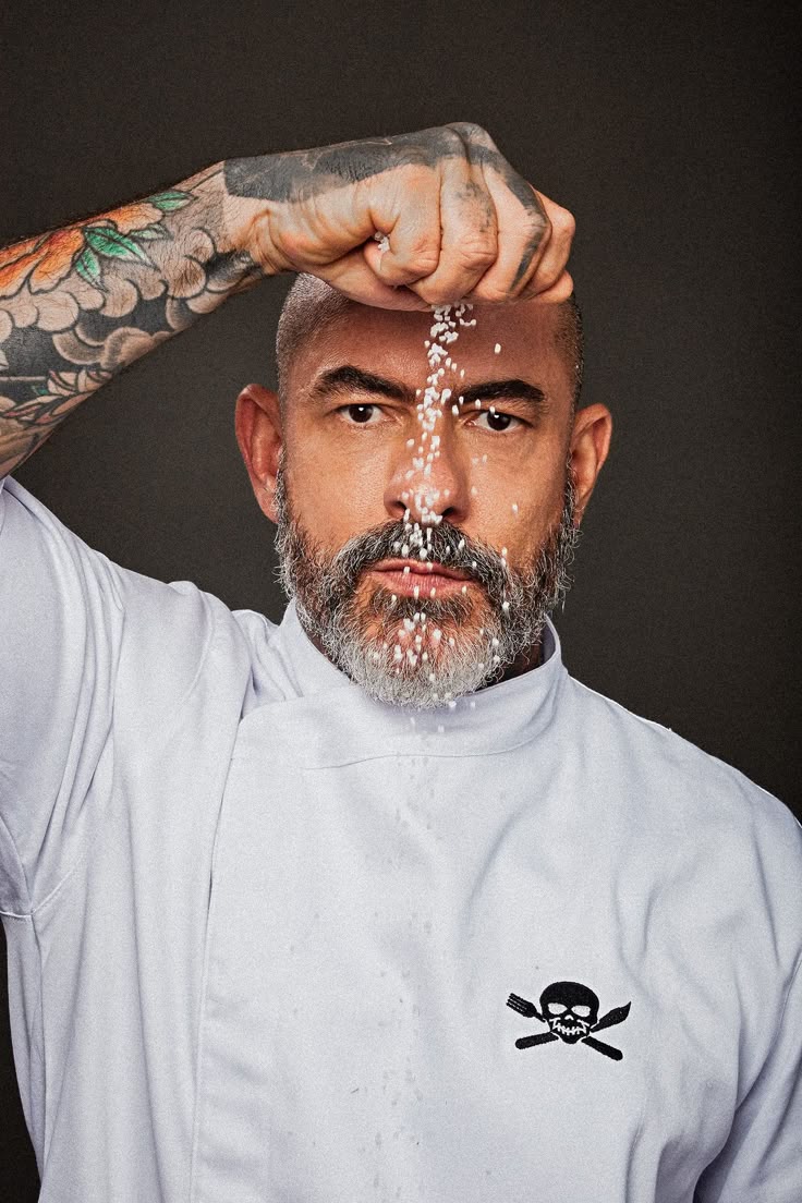 Chef de un restaurante dejando caer sal sobre su cara